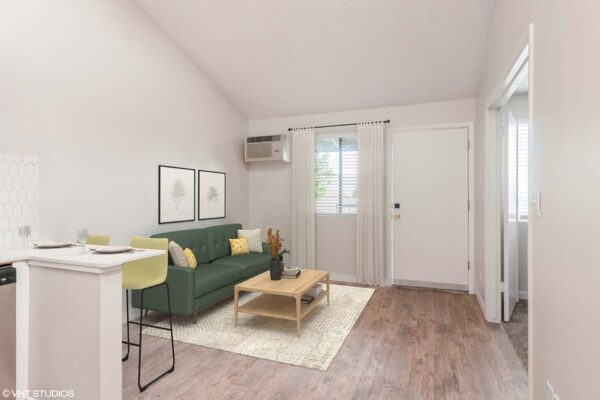 Overlook at Sunset Point apartment living room with wood style floor, plush couch, and breakfast bar with stools.