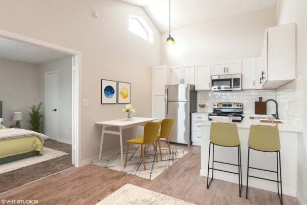 Overlook at Sunset Point apartment kitchen with wood style floor, white cabinets and counters, stainless steel appliances, and dining table.