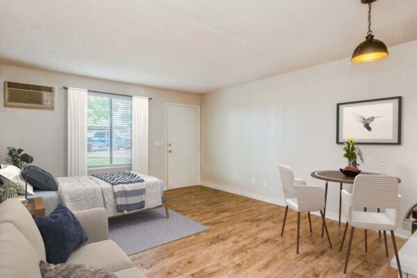Overlook at Sunset Point apartment studio living space with bed, plush seating, and dining table.