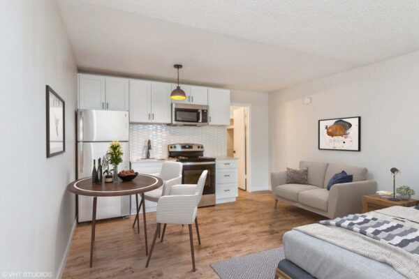 Overlook at Sunset Point apartment studio living space with bed, seating, kitchen, and dining table.