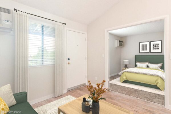 Overlook at Sunset Point apartment living area with wood style floor, plush couch, and double door to bedroom.