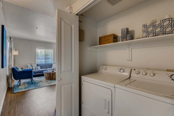 Pavilions at Arrowhead apartment laundry closet with washer and dryer and shelves.