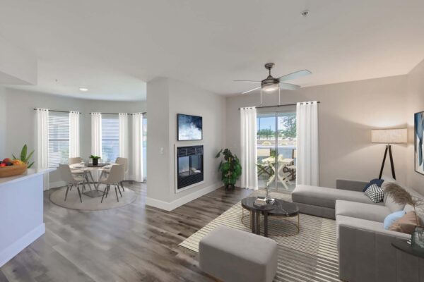 Pavilions at Arrowhead apartment living room with plush seating, fireplace, ceiling fan, and balcony door.