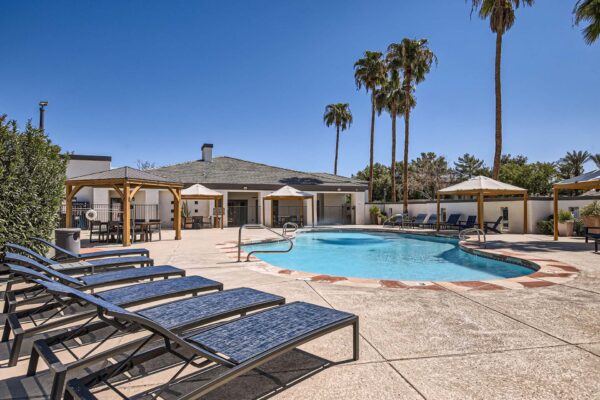 Pavilions at Arrowhead apartments pool area with lounge chairs and gazebos.