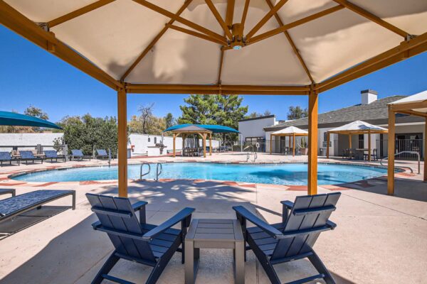 Pavilions at Arrowhead apartments pool area with lounge chairs and gazebos.