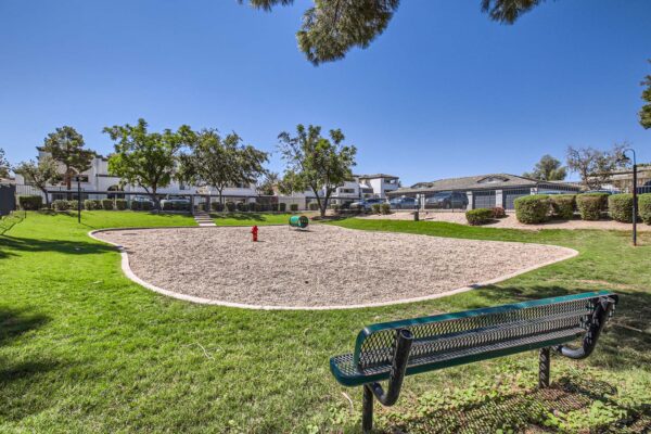 Pavilions at Arrowhead apartments dog park with lush lawn, benches, and dog agility toys.