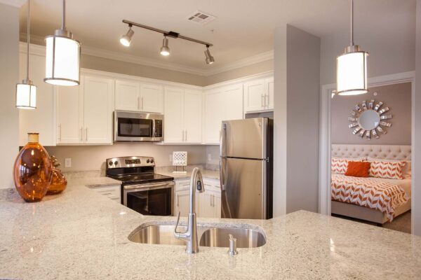 Prairie View at Village West apartment kitchen with white cabinets, light counters, and stainless steel appliances.