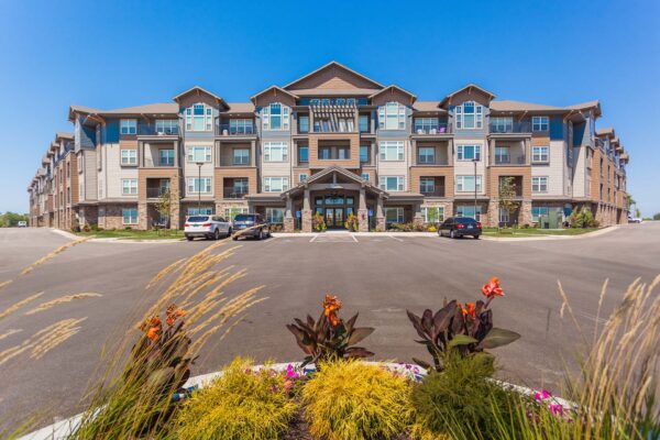 Prairie View at Village West apartments with classic architecture, lush landscaping, and ample parking.