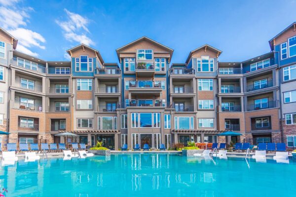 Prairie View at Village West apartments pool area with lounge chairs, umbrellas, and pergolas.