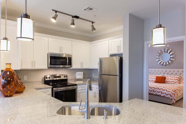 Prairie View at Village West apartment kitchen with white cabinets, light counters, and stainless steel appliances.