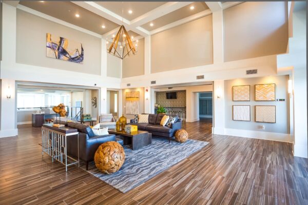 Prairie View at Village West apartments lobby with wood style floor, leather couches, and elegant light fixture.