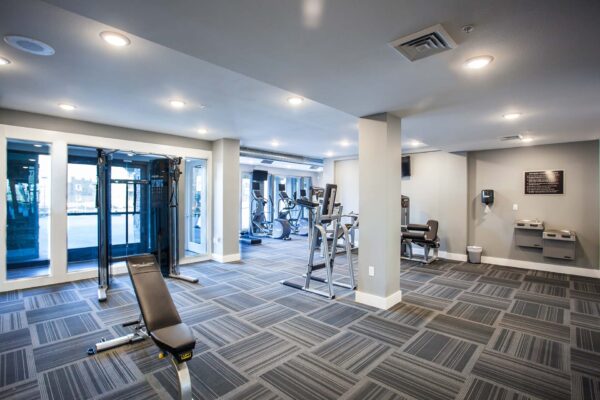 Prairie View at Village West apartments fitness center with cardio machines, weight equipment, and drinking fountains.