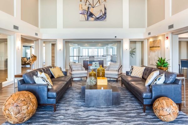 Prairie View at Village West apartments lobby with leather couches, elegant decor, and airy vaulted ceilings.