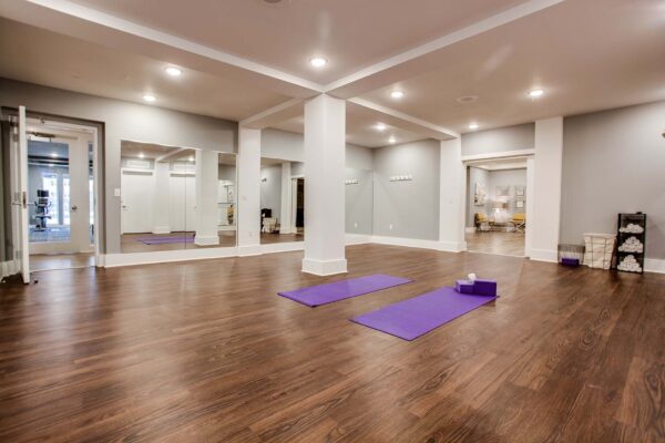 Prairie View at Village West apartments yoga room with wood style floor and mirror walls.
