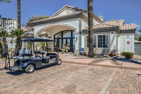Springs at Alta Mesa apartments leasing office with golf cart and tall palm trees.