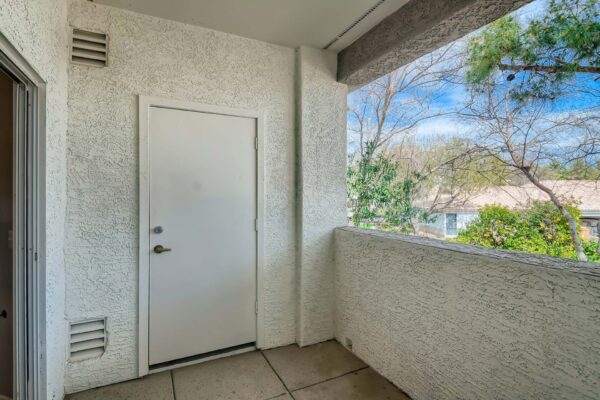 Springs at Alta Mesa apartment balcony with textured walls and storage closet.