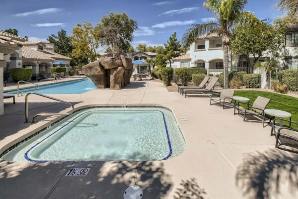 Springs at Alta Mesa apartments pool area with lounge chairs and hot tub.
