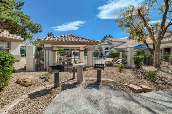 Springs at Alta Mesa apartment pool area with rocky landscaping and built in BBQ grills.