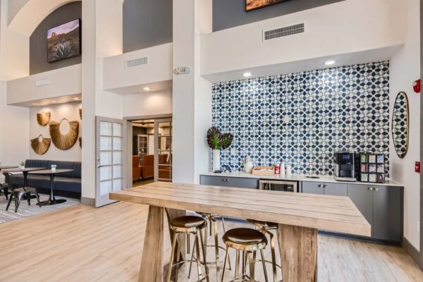 Springs at Alta Mesa apartments coffee bar with wood table, stools, and counter with coffee machine.