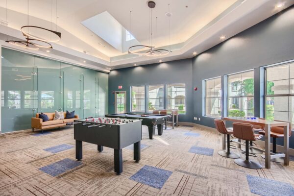 Springs at Alta Mesa apartments clubhouse with foosball, pool table, and large bright windows.