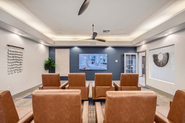 Springs at Alta Mesa apartments TV room with leather arm chairs and large TV.