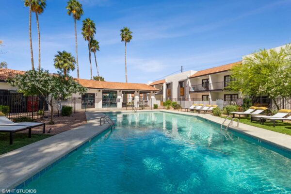 Tempe Vista apartments pool area with lounge chairs and tall palm trees.
