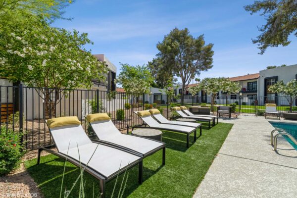 Tempe Vista apartments pool area with lounge chairs and lush landscaping.