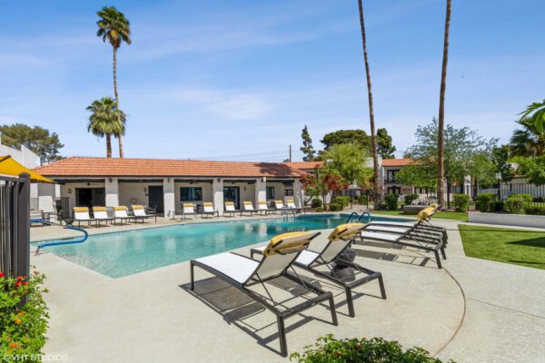 Tempe Vista apartments pool area with lounge chairs and tall palm trees.