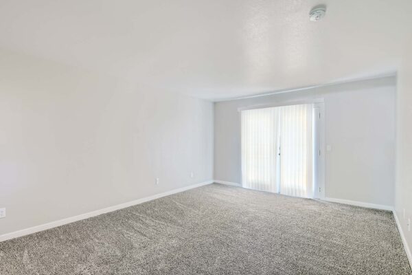 Tempe Vista apartment bedroom with plush carpet and balcony door.