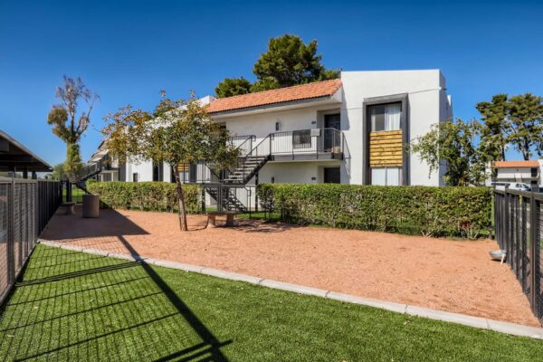 Tempe Vista apartments dog run with fenced play area and lush green lawn.