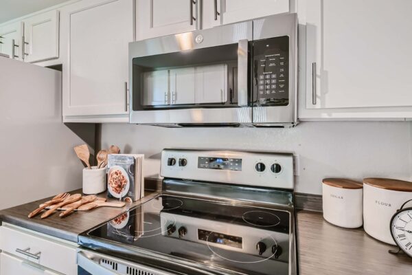 Tempe Vista apartment kitchen with white cabinets, dark counters, and stainless steel appliances.