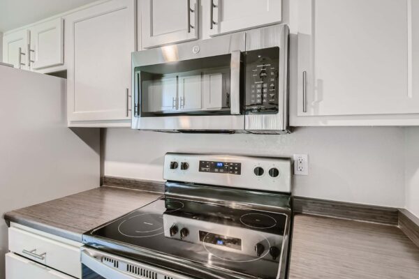 Tempe Vista apartment kitchen with white cabinets, dark counters, and stainless steel appliances.