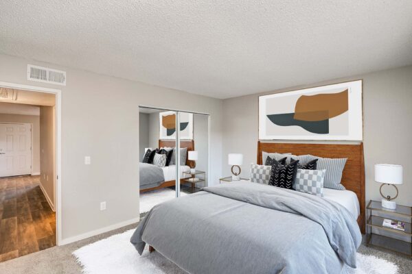 Tempe Vista apartment with carpet, plush bed with headboard, and framed artwork.