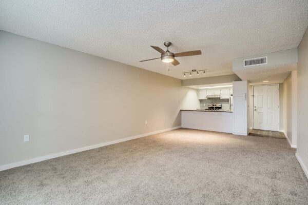 Tempe Vista apartment living area with plush carpet and ceiling fan.
