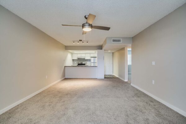 Tempe Vista apartment living area with plush carpet and ceiling fan.