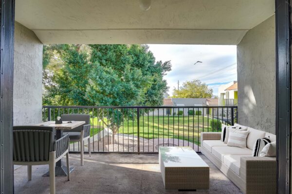 Tempe Vista apartment balcony with plush outdoor seating and railing overlooking courtyard.