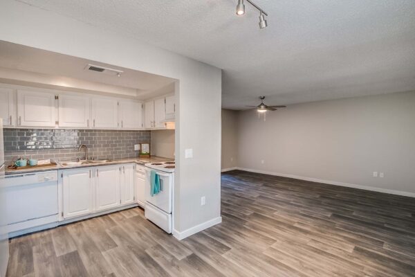 Tempe Vista apartment living area with wood style floor and modern kitchen.