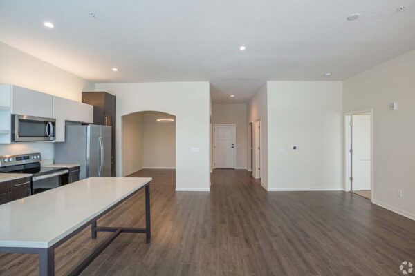 The Locale apartment living area with wood style floor and modern kitchen.
