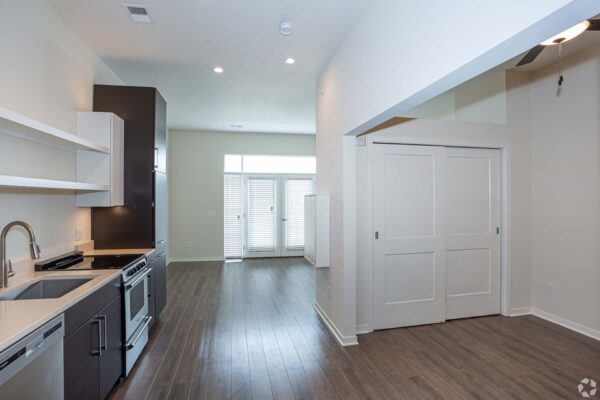 The Locale apartment living area with modern kitchen and wood style floors.