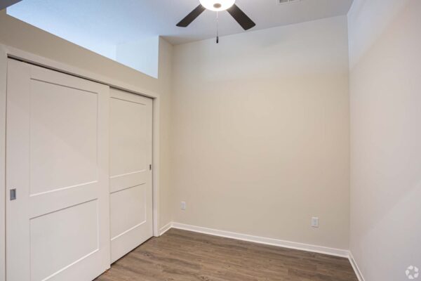 The Locale apartment living area with wood style floors and closet.