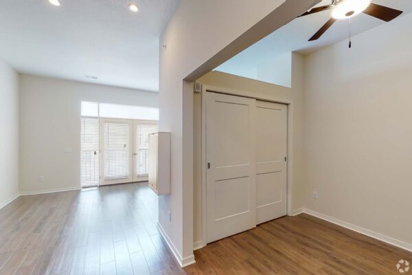 The Locale apartment living area with wood style floor, closet, and ceiling fan.