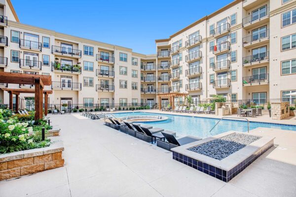 The Locale apartments pool area with lounge chairs and pergolas.