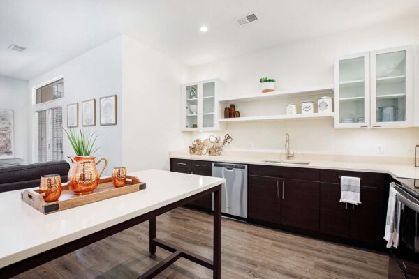The Locale apartment kitchen with wood style floor, two tone cabinets, and kitchen island table.