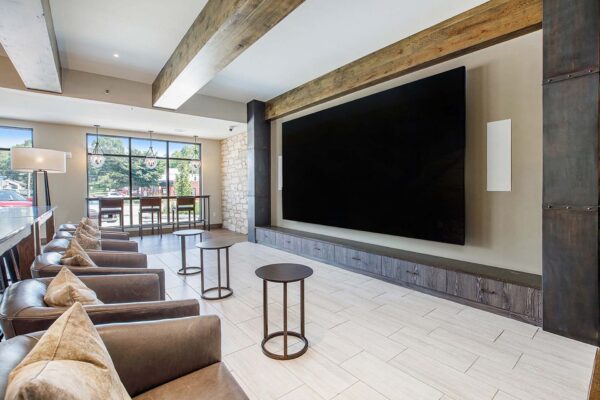 The Locale apartments clubroom with plush leather arm chairs and large TV screen.