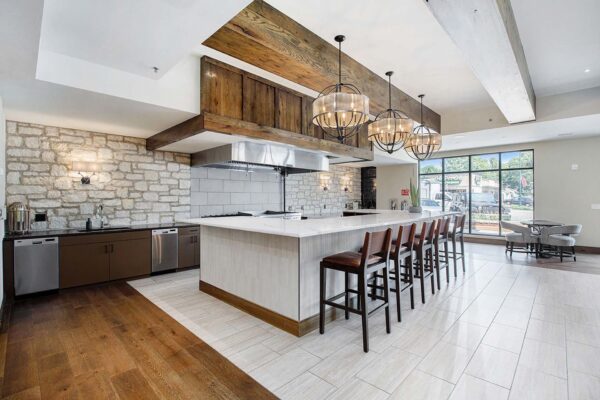 The Locale apartments community kitchen with large bar area and restaurant style appliances.