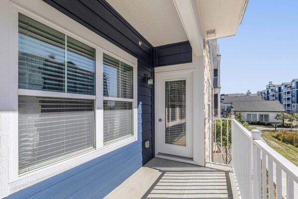 Village West apartment balcony overlooking grassy pond area.