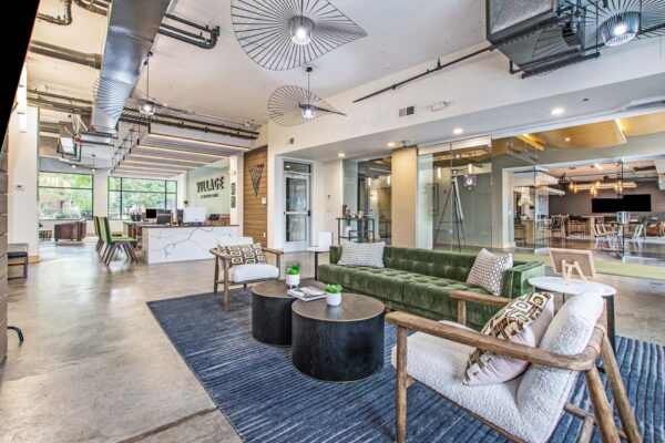 Village at Mission Farms apartments lobby with plush seating, large rug, modern lights, and eclectic decor.