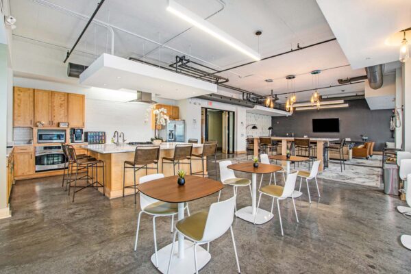 Village at Mission Farms apartment community kitchen with dining tables and restaurant style appliances.