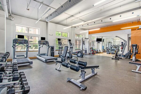 Village at Mission Farms apartments fitness center with cardio machines and weight equipment.