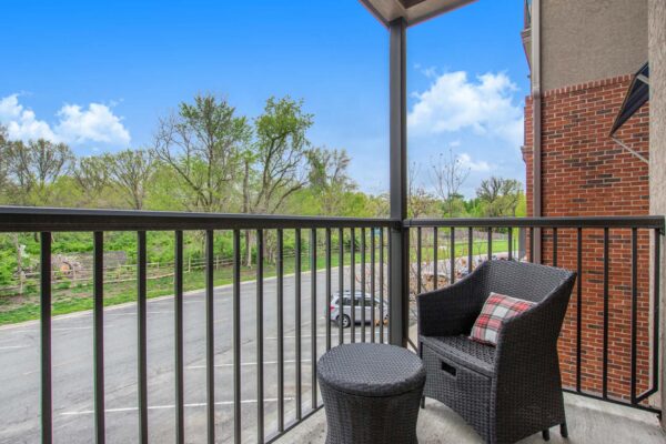 Village at Mission Farms apartment balcony with chair and ottoman.